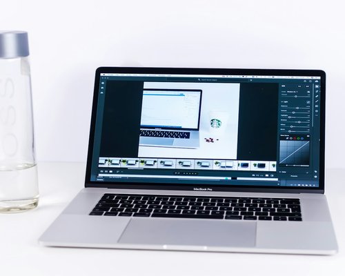 glass of water next to a modern computer keyboard